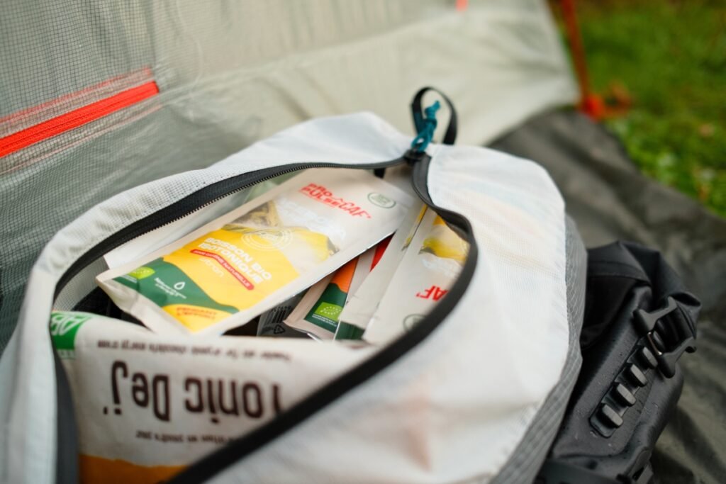Test des boissons, gels et barres 100 % naturels de Natural Origins 6 Sachets BioTonic Natural Origins dans une sacoche de bikepacking, à côté d'une tente