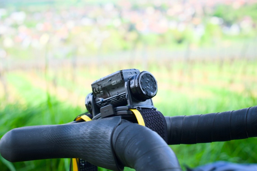 Test & Avis Nitecore HC65 UHE : La lampe frontale ultime pour le bikepacking ? 8 Lampe frontale Nitecore HC65 UHE fixée au guidon, montrée sous la pluie pour illustrer son étanchéité IPX8
