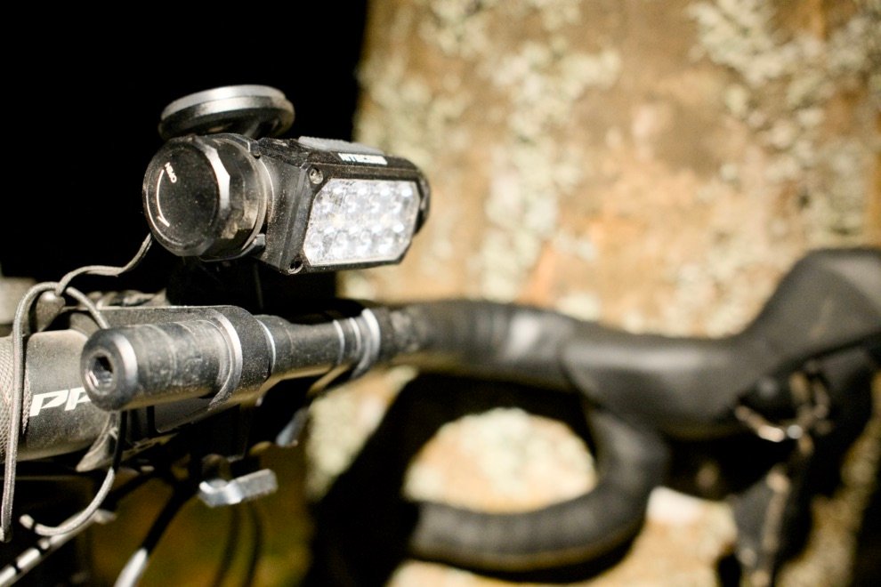 Test & Avis Nitecore HC65 UHE : La lampe frontale ultime pour le bikepacking ? 9 Lampe frontale Nitecore HC65 UHE fixée sur le guidon d’un vélo gravel pour une sortie de nuit en bikepacking