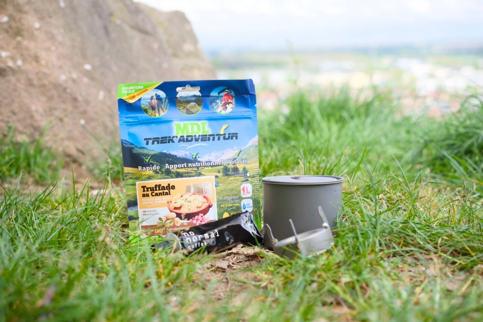 Les meilleurs réchauds pour le bivouac 17 Plat lyophilisé Trek'Adventur avec popote en aluminium, posé dans l’herbe lors d’un bivouac