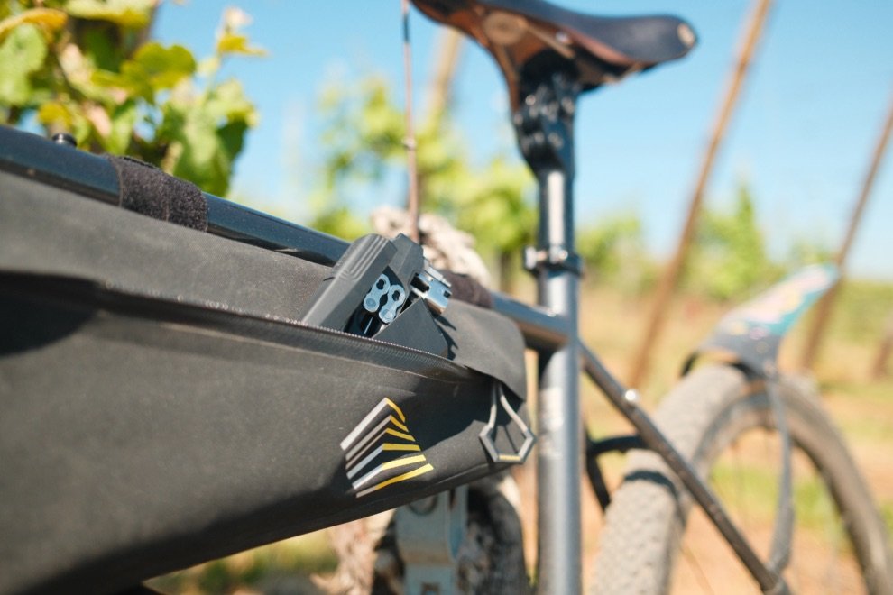 Multi-outil DaySaver glissé dans une sacoche de cadre pendant un test terrain en bikepacking
