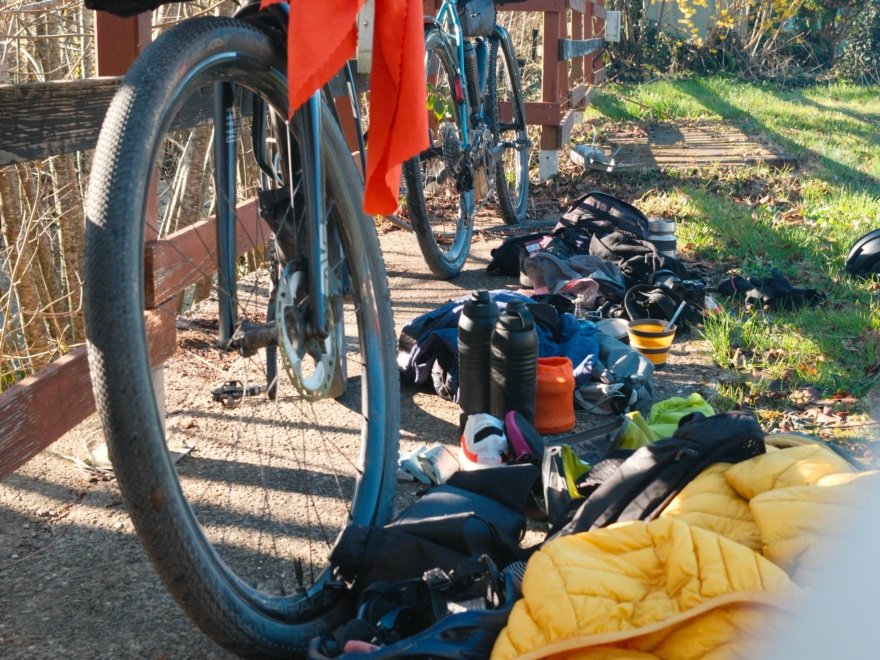 Matériel de bikepacking déballé devant un vélo : contenu typique d’une sacoche de selle