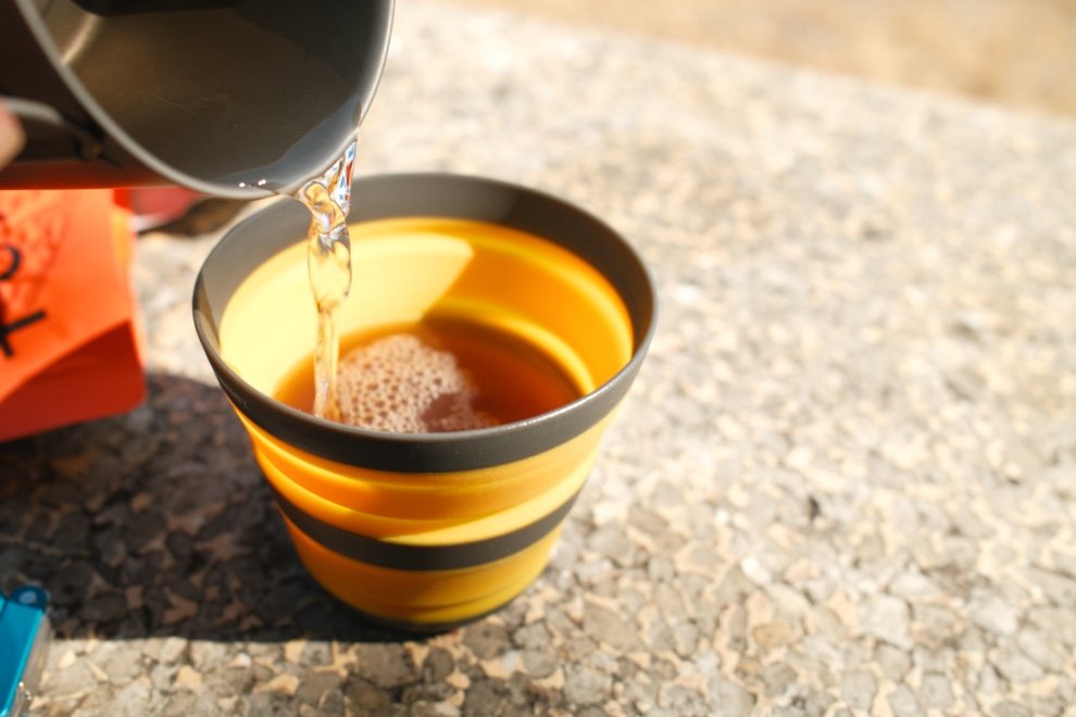 Test No Normal Coffee : Le café pour l’aventure et le bikepacking ? 10 Préparation du café No Normal Coffee avec de l’eau chaude versée dans une tasse pliable en bikepacking