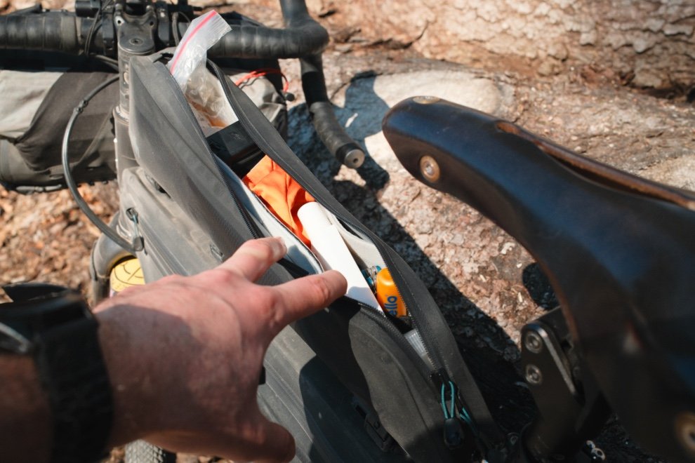Vue intérieure de la sacoche Tailfin Long Top Tube Bag montrant le rangement et le compartimentage pendant un voyage bikepacking