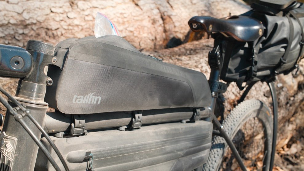 Sacoche Tailfin Long Top Tube Bag montée sur un vélo de bikepacking pendant un test terrain en forêt