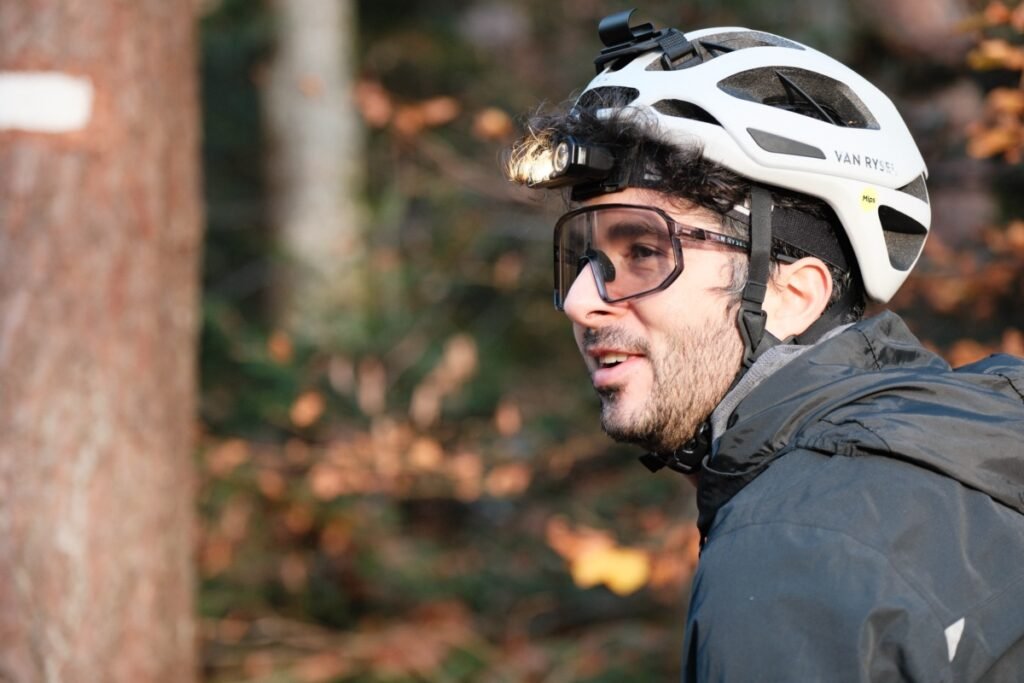 Lampe frontale Stoots Opalo 3 fixée sur un casque de vélo, montrant que l’usage du support casque est optionnel.