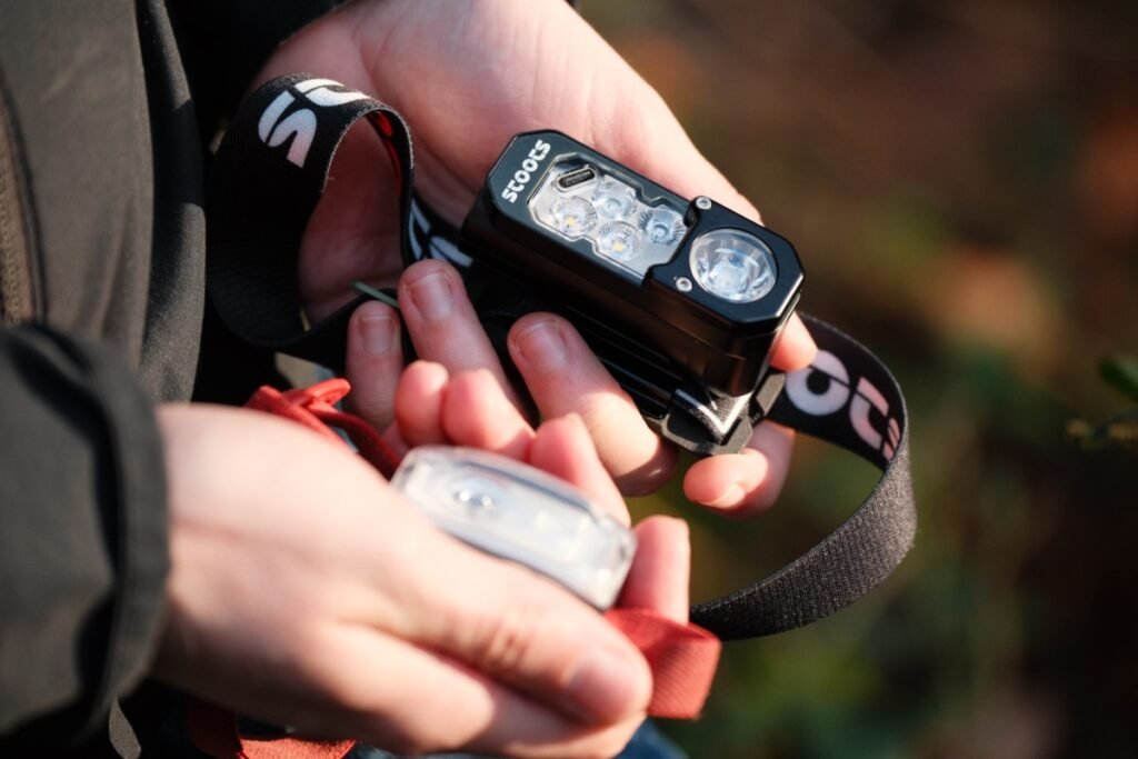 Comparaison entre la lampe frontale Stoots Opalo 3 et une frontale Decathlon tenue en main.