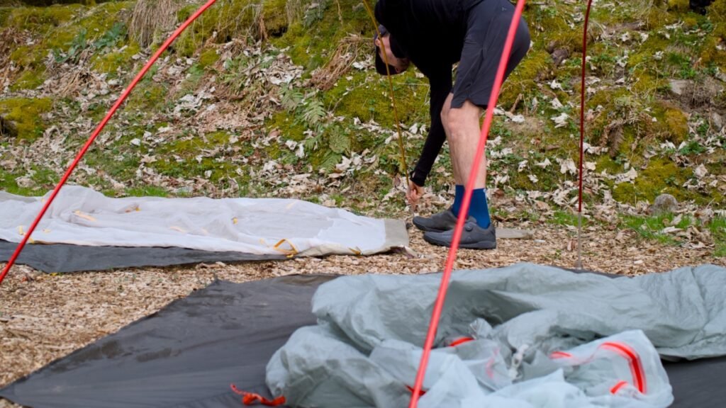 Montage d’une tente en pleine nature lors d’un bivouac en bikepacking