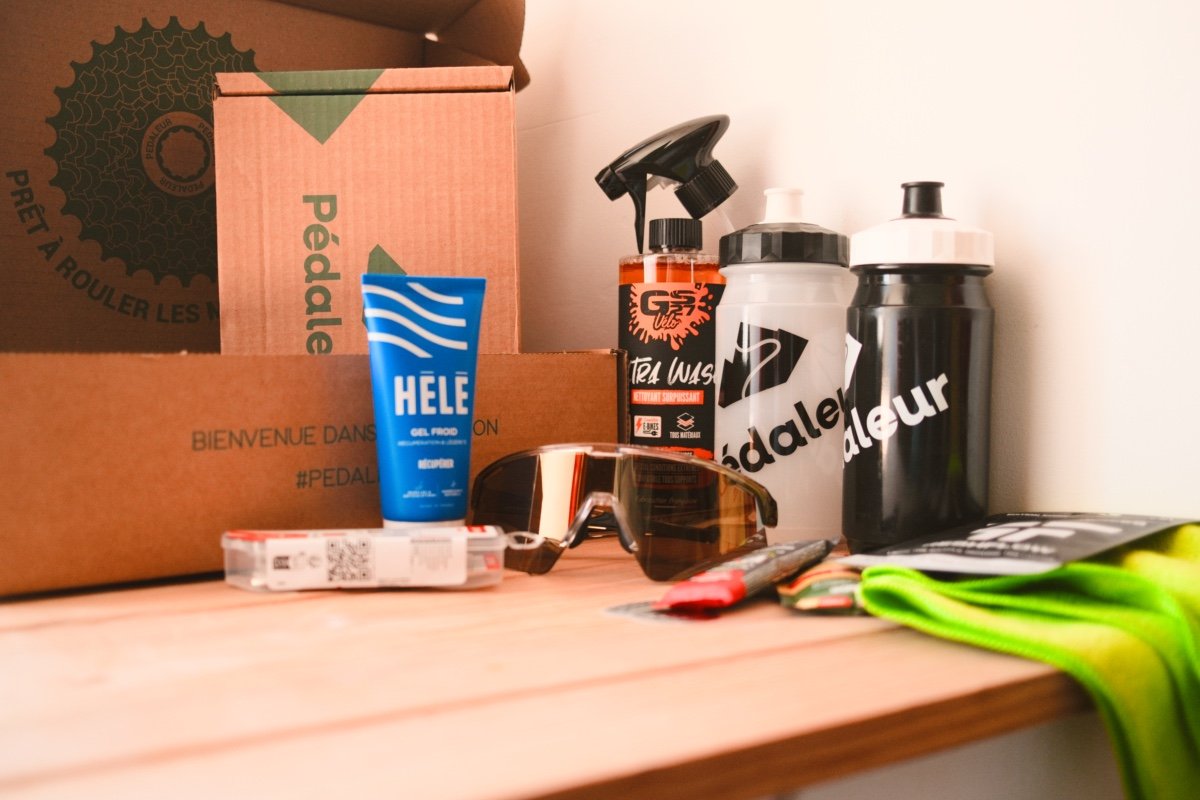 Box Pédaleur : mon avis honnête, ça vaut vraiment le coup ? 1 Carton Pédaleur et produits de la box : gel froid HELE, nettoyant GS27, bidons Pédaleur, lunettes Juyar et chiffon