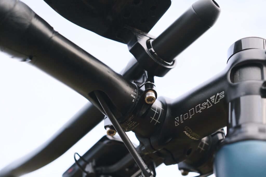 Prolongateur vélo : le guide complet pour bien choisir 9 Gros plan sur le collier de fixation et la vis de réglage d'un prolongateur vélo monté sur le cintre
