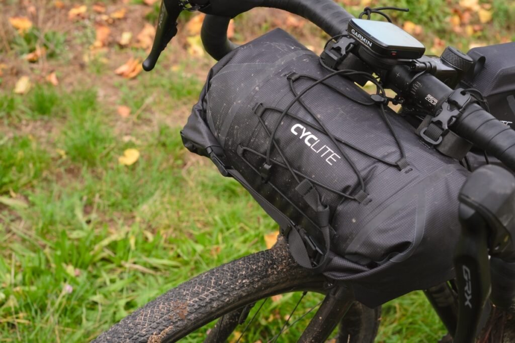 Les meilleures sacoches de guidon bikepacking : sélection et conseils 21 Sacoche de guidon imperméable éclaboussée de boue sur un gravel en conditions humides