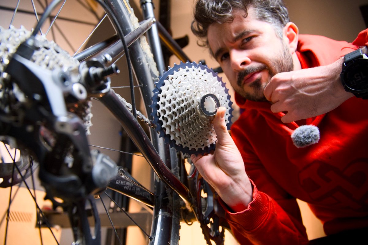 Marvin Alther inspecte une cassette démontée dans son atelier, la transmission de son vélo en cours de révision.
