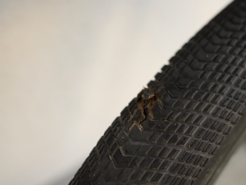 Traversée de la Forêt-Noire en gravel : 544 km en 5 jours, du pneu éclaté à la tente gelée 3 Gros plan sur l'entaille au milieu de la bande de roulement d'un pneu gravel Tufo Speedero, avec des picots arrachés et des traces brunes autour de la déchirure